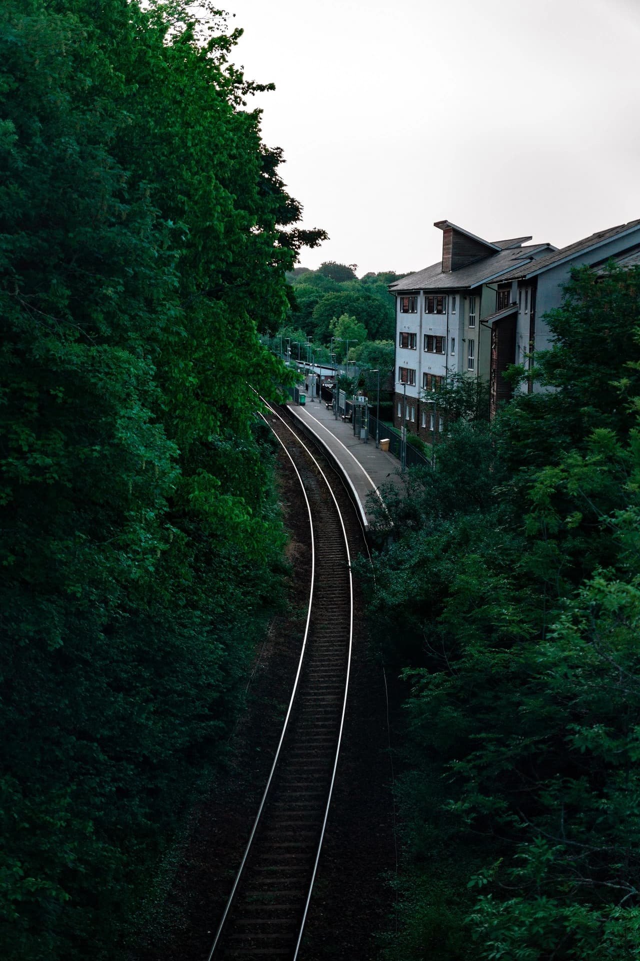 photo of train tracks running up to a station next to some buildings