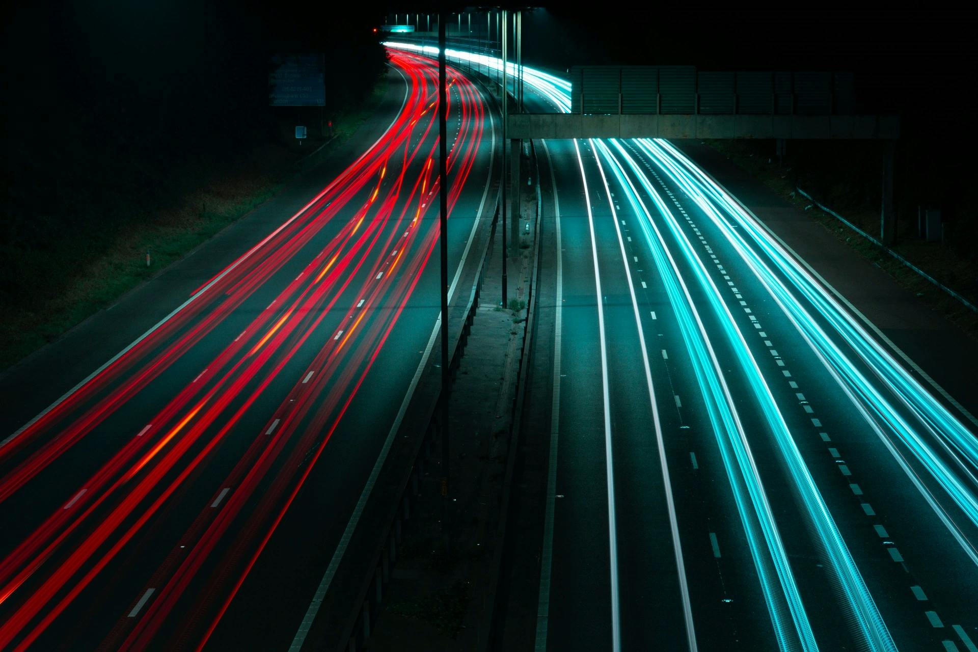 photo of a highway taken from above showing the headlight and brakelight lighttrails left from cars